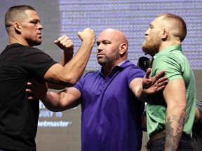 Dana White (centre) stands between Nate Diaz (left) and Conor McGregor (right) during a news conference in Las Vegas for UFC 202 on July 7, 2016. McGregor was fined $150,000 by the Nevada Athletic Commission for a profanity-laced bottle-throwing fracas that erupted during a pre-fight news conference with Diaz in August. (John Locher/AP Photo/Files)
