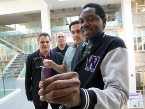 Western University physics Ph.D. candidates Sebastine Ezugwu, right, and Joe Paquette, second from right, display their work with assistant physics professor Dr. Giovanni Fanchini, left, and chemistry assistant professor Joe Gilroy. The team discovered how to transform organic material, held by Paquette in a vial, into a thin, flexible material suitable for memory storage. (CRAIG GLOVER, The London Free Press)