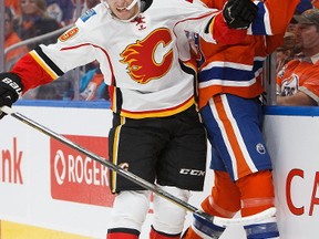 EDMONTON, AB - OCTOBER 12:  Brandon Davidson #88 of the Edmonton Oilers is taken to the boards by Matthew Tkachuk #19 of the Calgary Flames on October 12, 2016 at Rogers Place.