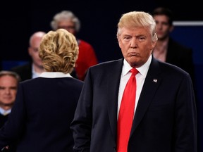 Democratic presidential nominee former Secretary of State Hillary Clinton (L) and Republican presidential nominee Donald Trump listen to a question during the town hall debate at Washington University on October 9, 2016 in St Louis, Missouri. This is the second of three presidential debates scheduled prior to the November 8th election. (Photo by Saul Loeb-Pool/Getty Images)