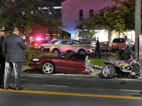 Police survey the wreckage of a Mazda Miata that was split in half after a collision with a Mercedes-Benz in Rockville Centre, on New York’s Long Island, Friday Oct. 14, 2016. (Paul Mazza/Newsday via AP)