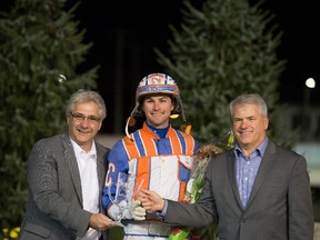 Dan Gall, President & CEO of Standardbred Canada, left, and Mike Woods, chief operating officer of Western Fair District, congratulate 2016 National Driving Champion Brandon Campbell. (Photo credit: Jake MacDonald/Western Fair District)