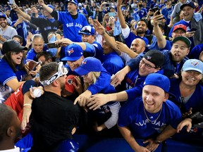 Marco Estrada of the Toronto Blue Jays is swarmed by fans after the Blue Jays defeated the Texas Rangers in Game 3 of the American League Division Series at Rogers Centre on Oct. 9, 2016 in Toronto. (Vaughn Ridley/Getty Images)