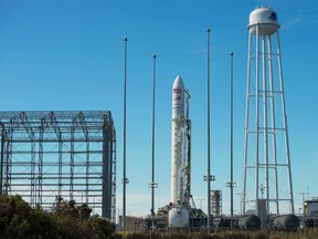 An Orbital ATK Antares rocket carrying the Cygnus spacecraft is raised into the vertical position on launch Pad-0A at NASA's Wallops Flight Facility in Virginia. The Sunday, Oct. 16, 2016 scheduled cargo resupply mission to the International Space Station would be the company’s first Antares launch since an explosion seconds after liftoff in 2014, which destroyed the rocket and space station supply ship, and damaged the launch complex. (Bill Ingalls/NASA via AP)