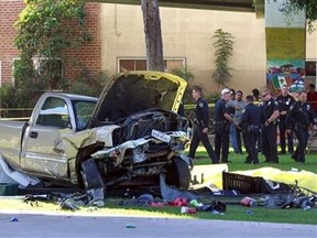 Police stand near the pickup truck that landed at Chicano Park after it flew off a ramp to the San Diego Coronado Bridge in San Diego on Saturday, Oct. 15, 2016. Four people were killed and nine were injured on Saturday after an out-of-control pickup truck plunged off the San Diego-Coronado Bridge and plowed into crowd gathered at a festival below, authorities said. (Hayne Palmour IV/The San Diego Union-Tribune via AP)