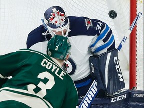 Winnipeg Jets goalie Michael Hutchinson, right, blocks a shot by Minnesota Wild's Charlie Coyle. (AP)