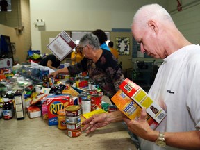 Volunteer Brian Riker collects food during the sorting process of the Gleaners Food Bank food drive Sunday in Belleville.