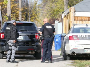 Winnipeg Police officers confer following an incident in the 400 block of College Avenue in Winnipeg, Man. Sunday, Oct. 16, 2016. (Brian Donogh/Winnipeg Sun/Postmedia Network)