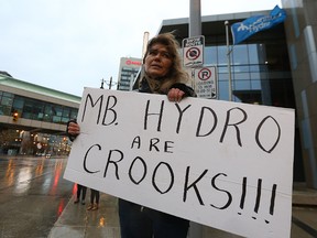 Velvet Sayer holds a sign during a vigil for her brother-in-law Joseph Head in front of Manitoba Hydro headquarters on Portage Avenue. (KEVIN KING/Winnipeg Sun)