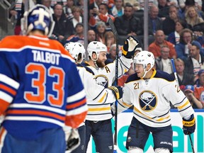 The Buffalo Sabrres celebrate a goal on as Oilers netminder Cam Talbot looks on during Sunday's game at Rogers Centre. (The Canadian Press)