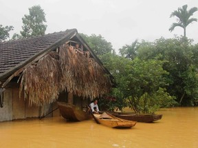 A Vietnamese villager sits on a boat next to his flooded home in Huong Khe district in the central province of Ha Tinh on October 15, 2016. (VIETNAM NEWS AGENCY/AFP/Getty Images)