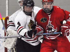 Trevor Skinner (4) of the Mitchell Hawks tries to move Cole Leslie (21) of the Hanover Barons from in front of the net during Provincial Junior Hockey League (PJHL) action in Mitchell last Saturday, Oct. 15, a 6-2 loss. ANDY BADER MITCHELL ADVOCATE