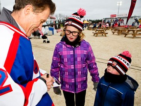 Former Winnipeg Jets captain (1980-81) Morris Lukowich signs autographs for Tuera Newton and her brother Taigan at the Rogers Hometown Hockey Tour Sat., Oct. 18, 2014 in Selkirk, MB. (Brook Jones/Selkirk Journal/QMI Agency)