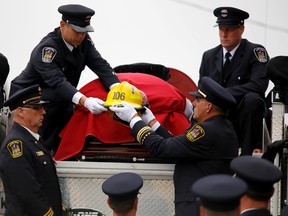 Emily Mountney-Lessard/The Intelligencer
The helmet of Quinte West firefighter Jason Forth is lowered from the back of a fire truck just before Forth's celebration of life at Trenton United Church, Monday October 17, 2016 in Trenton, Ont. Forth, 43, died on Oct. 11 after a long battle with cancer. He was a full-time firefighter with Station 1 in Trenton.