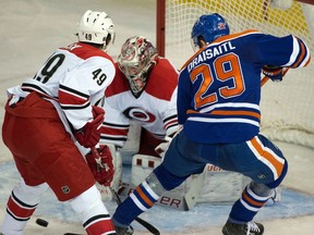 Hurricanes goalie Cam Ward makes a save with Leon Draisaitl and Victor Rask in front as the Hurricanes played the Oilers in Edmonton last January. (File)