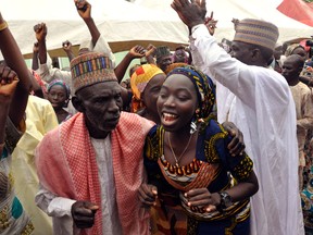 Family members celebrate after being reunited with the kidnapped girls during an church survives held in Abuja, Nigeria, Sunday, Oct. 16, 2016. The girls were released Thursday and flown to Abuja, Nigeria's capital, but it's taken days for the parents to arrive. The families came from the remote northeastern town of Chibok, where nearly 300 girls were kidnapped on April 2014 in a mass abduction that shocked the world. Dozens of schoolgirls escaped in the first few hours but after last week's release, 197 remain captive. (AP Photo/Olamikan Gbemiga)