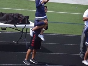 Central Catholic High School senior student Matthew Garcia rescues Addie Rodriguez, 9, during a cheerleading routine last week. Rodriguez was lifted over Garcia's shoulders, joining the other cheerleaders in the routine. (Screen capture)