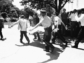 In this Aug. 1, 1966, file photo, one of the victims of Charles Whitman, the sniper who gunned down victims from a perch in the University of Texas tower, is carried across the campus to a waiting ambulance in Austin. The unidentified victim was gunned down inside the tower, according to police on the scene. The new documentary "Tower" about the shooting spree captures a sense of terror and confusion that was unprecedented then as it has become chilling commonplace today. (AP Photo/File)