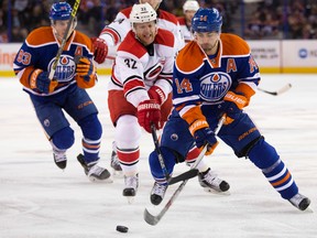 The Edmonton Oilers' Jordan Eberle (14) battles the Carolina Hurricanes Kris Versteeg (32) during first period NHL action at Rexall Place, in Edmonton Alta. on Monday Jan. 4, 2016.