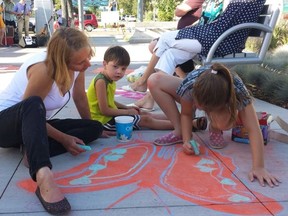 Artist Agnieszka Matejko leads two children in a chalk drawing at the scaled-back public market, which operated on Stony Plain Road every Friday this summer. STONY PLAIN ROAD, SUPPLIED