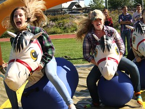 Tory Arnold, left, Britney Nutt, and Grace Renner at the inflatable horse races activity on Ag Day.