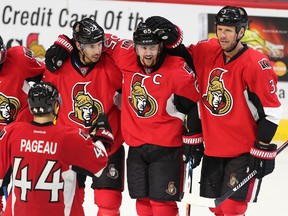 Senators captain Erik Karlsson is congratulated on his empty net goal against the Coyotes in the final seconds of the third period by teammates (from left), Tom Pyatt, JG Pageau, Chris Kelly and Marc Methot during NHL action at the Canadian Tire Centre in Ottawa on Tuesday, Oct. 18, 2016. (Wayne Cuddington/Postmedia)