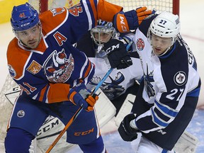 Bakersfield Condors right winger Taylor Beck (l) and Manitoba Moose defenceman Kevin Czuczman tangle in front of Moose goalie Eric Comrie during AHL hockey in Winnipeg, Man. Tuesday October 18, 2016. Brian Donogh/Winnipeg Sun/Postmedia Network