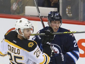 Winnipeg Jets rookie forward Patrik Laine (right) tangles with Boston Bruins defenceman Brandon Carlo on Oct. 17, 2016, in Winnipeg. (BRIAN DONOGH/Postmedia Network)