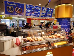 In this Tuesday, Oct. 18, 2016 photo, customer purchase Pretzel at Auntie Anne's at a shopping mall in Kuala Lumpur, Malaysia. Hot dogs, or at least the name, will soon be off the menu for a U.S. fast food chain selling the popular snack in Malaysia. The chain, Auntie Anne's, has been told by Islamic authorities that its popular Pretzel Dog, which contains no dog meat, has to be renamed as it is confusing for Muslim consumers. (AP Photo/Vincent Thian)