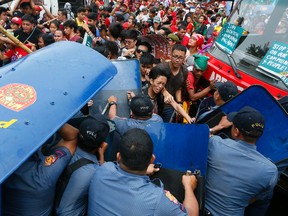 Police and protesters clash during a violent protest outside the U.S. Embassy in Manila, Philippines Wednesday, Oct. 19, 2016. A Philippine police van rammed into protesters, leaving several bloodied, as an anti-U.S. rally turned violent Wednesday at the American embassy in Manila. (AP Photo/Bullit Marquez)