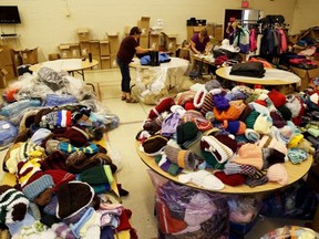 Emily Mountney-Lessard/The Intelligencer
Volunteers work away at sorting donated winter wear for the Adopt-A-Child program at the Belleville Police Services station, on Wednesday in Belleville.