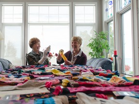 Lesley Zolob, left, shares a laugh with Mary Ellen Jasper as the two friends play with what they call happy socks that will be donated to children suffering from cancer. Zolob, who was diagnosed with cancer in May, started the donation initiative Sock it to Cancer so children can have warm feet and a little cheer while receiving their cancer treatment at the local London hospital. (Darryl Coote/The Goderich Signal Star)