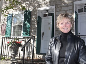 Real estate agent Marni Lockington stands in front of the one-time home of Sir John A. Macdonald on Rideau Street in Kingston on Friday. The home, where he lived from 1835 to 1839, is now for sale. (Michael Lea/The Whig-Standard)