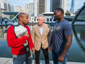 Tom Wright (centre) is flanked by UFC light heavyweight champion Daniel Cormier (left) and Anthony Johnson (right) at Nathan Phillips Square in Toronto on Tuesday, Oct. 18, 2016. Wright, UFC Executive VP and GM, Canada, Australia & New Zeland, was one of many employees let go at the UFC's office in Toronto. (Ernest Doroszuk/Toronto Sun)
