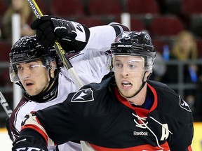 Gee-Gees forward Justin Charbonneau (left) is held up by Ravens defenceman David Weckworth as the Carleton Ravens defeated the Ottawa Gee-Gees in the Colonel By Classic.  (Wayne Cuddington/Postmedia Network)