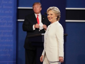 Democratic presidential nominee Hillary Clinton walks toward the audience as Republican presidential nominee Donald Trump stands behind his podium after the third presidential debate at UNLV in Las Vegas, Wednesday, Oct. 19, 2016. (AP Photo/John Locher)