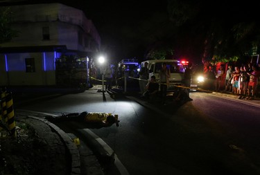 In this Sept. 5, 2016 photo, the body of alleged drug user Marcelo Salvador lies on the pavement after being shot by unidentified men in Las Pinas, south of Manila, Philippines. Drug dealers and drug addicts, were being shot by police or slain by unidentified gunmen in mysterious, gangland-style murders that were taking place at night. Salvador became a victim, the casualty of a vicious war on drugs that has claimed thousands of lives as part of a campaign by Philippine President Rodrigo Duterte. (AP Photo/Aaron Favila)