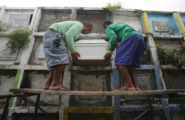 In this Sept. 14, 2016 photo, cemetery workers carry the coffin of alleged drug user Marcelo Salvador during funeral rites in Las Pinas, south of Manila, Philippines. Drug dealers and drug addicts, were being shot by police or slain by unidentified gunmen in mysterious, gangland-style murders that were taking place at night. Salvador became a victim, the casualty of a vicious war on drugs that has claimed thousands of lives as part of a campaign by Philippine President Rodrigo Duterte. (AP Photo/Aaron Favila)