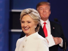 Democratic presidential nominee Hillary Clinton walks off stage as Republican presidential nominee Donald Trump puts his notes away after the third presidential debate at UNLV in Las Vegas, Wednesday, Oct. 19, 2016. (AP Photo/John Locher)