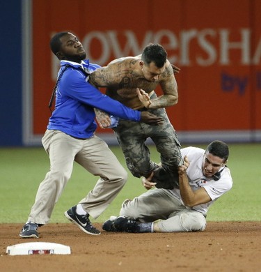 A fan is tackled on the field late in the game as Cleveland beat the Toronto Blue Jays 3-0 to win the ALCS in Toronto on Wednesday Oct. 19, 2016.. Stan Behal/Toronto Sun/Postmedia Network