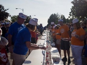 In this June 11, 2016 file photo, an ice cream sundae is completed during the world record attempt for the longest ice cream dessert along eight city blocks in Ludington, Mich. (Erin Lefèvre/Muskegon Chronicle-MLive.com via AP, File)