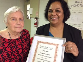Christine McMillan, president of Oasis, presents a certificate to United Way CEO Bhavana Varma. (Paul Schliesmann/The Whig-Standard)