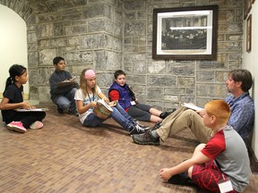 Centennial Public School teacher Skot Caldwell works with students, from left, Eh K'lu, Haadi Jalaud, Trinity Fairman, Addison Rawcliffe and Peyton Vanalstyne in the royalty hall in the basement of city hall in Kingston on Thursday. They were in the building for a week as part of the Beyond Classrooms program. (Michael Lea/The Whig-Standard)