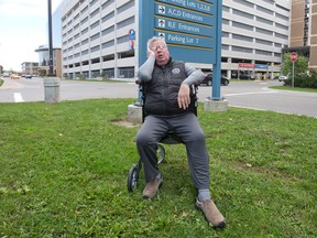 Michael Laliberte, who has been waiting five months to get the proper drug injections to relieve pain that has left him using a walker, sits outside of LHSC's Victoria Hospital campus. Craig Glover/The London Free Press/Postmedia Network