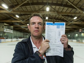 Jeff Duggan poses with a hydro bill at Vic Johnston arena in Mississauga, Ont. on Wednesday October 19, 2016. Above, are the recently upgraded LED lights. Ernest Doroszuk/Toronto Sun/Postmedia Network
