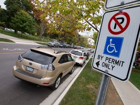 A sign on a post identifies this Dufferin Avenue parking spot, near the corner of Richmond Street, is for drivers with a disability permit, in London, Ont. on Tuesday October 18, 2016. Rick Gleed believes the space needs more than minimum signage, such as markings on the pavement, as the space generates many tickets. Craig Glover/The London Free Press/Postmedia Network