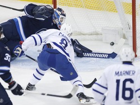 Toronto Maple Leafs' Connor Carrick scores on Winnipeg Jets goaltender Michael Hutchinson during first period NHL action in Winnipeg on Wednesday, October 19, 2016. (THE CANADIAN PRESS/John Woods)