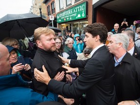 Prime Minister Justin Trudeau, second right, and RCMP security handle a man who was getting in the face of Trudeau after he toured Picone Fine Food in Dundas, Ont., on Friday, October 21, 2016. The issue was settled and no one was arrested. THE CANADIAN PRESS/Nathan Denette