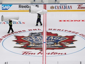 Workers put the finishing touches to the NHL's Heritage Classic outdoor rink in Winnipeg on Thursday, October 13, 2016. Winnipeg will host games between current and alumni players from the Winnipeg Jets and Edmonton Oilers this weekend.