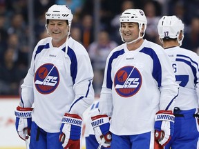 Former Winnipeg Jets Dave Ellett, left, and Dale Hawerchuk take a breather during a practice for the NHL's Heritage Classic Alumni game in Winnipeg on Friday, October 21, 2016. Winnipeg will host games between current and alumni players from the Winnipeg Jets and Edmonton Oilers this weekend. THE CANADIAN PRESS/John Woods